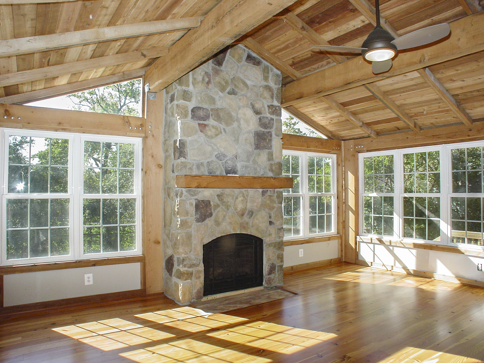 Cook Bros. Arlington Design Build Remodeling Contractor Services: _Sunroom Addition with Stone Fireplace, Timber Frame roof and ceiling on an Arlington Colonial home